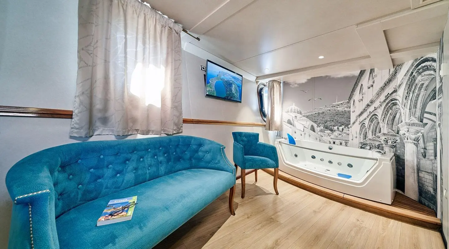 Interior of Casablanca yacht cabin with blue couch, TV, and patterned wall art