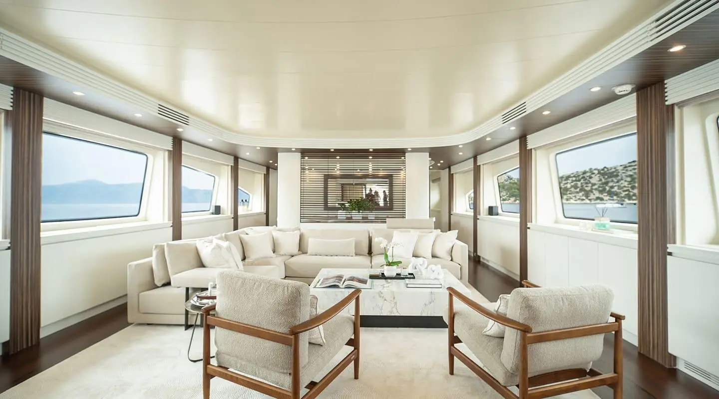 Inside Pareaki II saloon with white seating, large windows, and a central coffee table