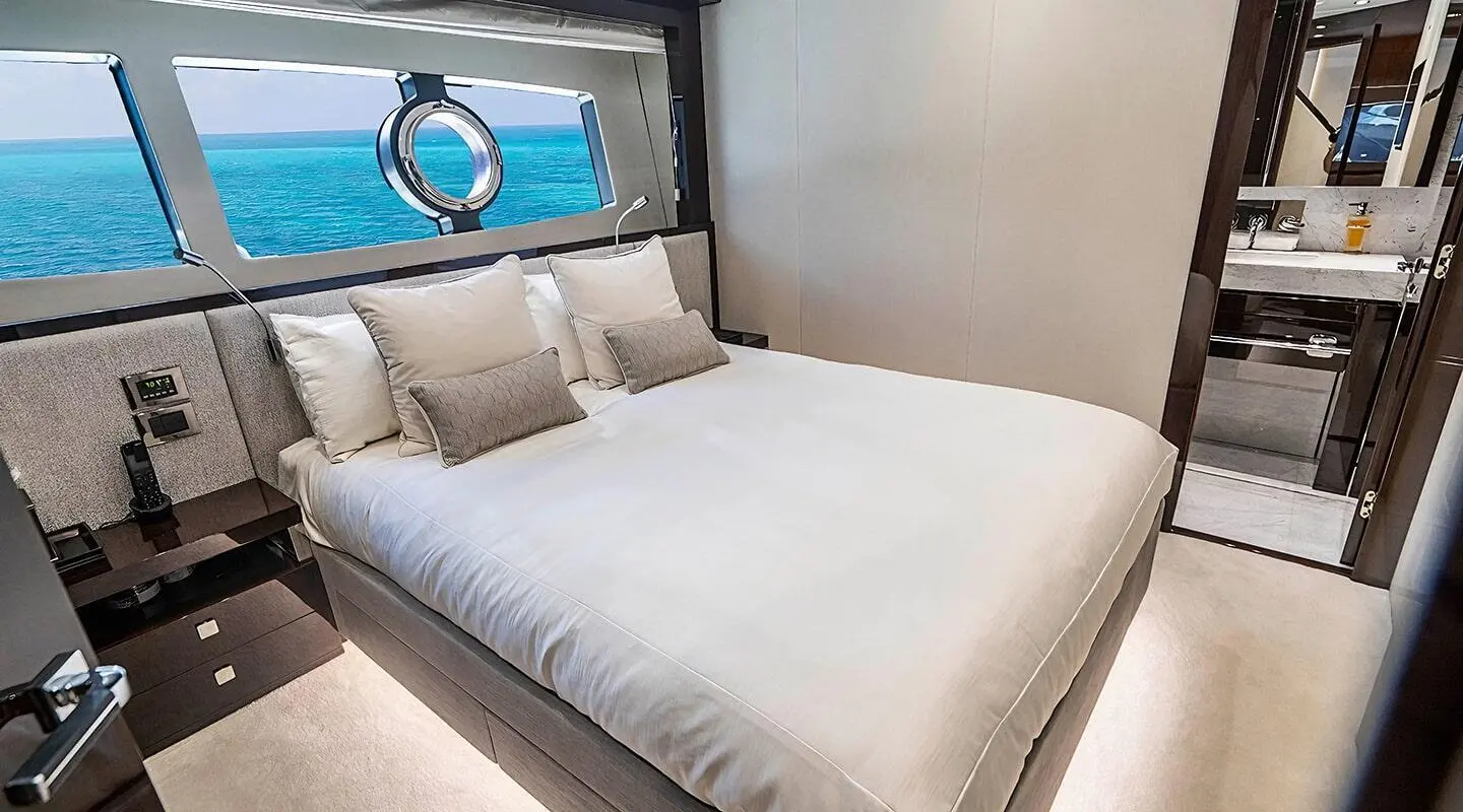 Quantum yacht stateroom with a large bed, white linens, and window view