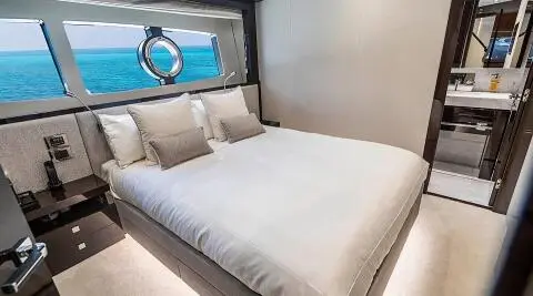 Quantum yacht stateroom with a large bed, white linens, and window view