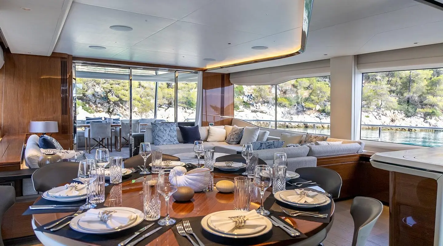 Interior of Vista motoryacht dining saloon with table settings and windows