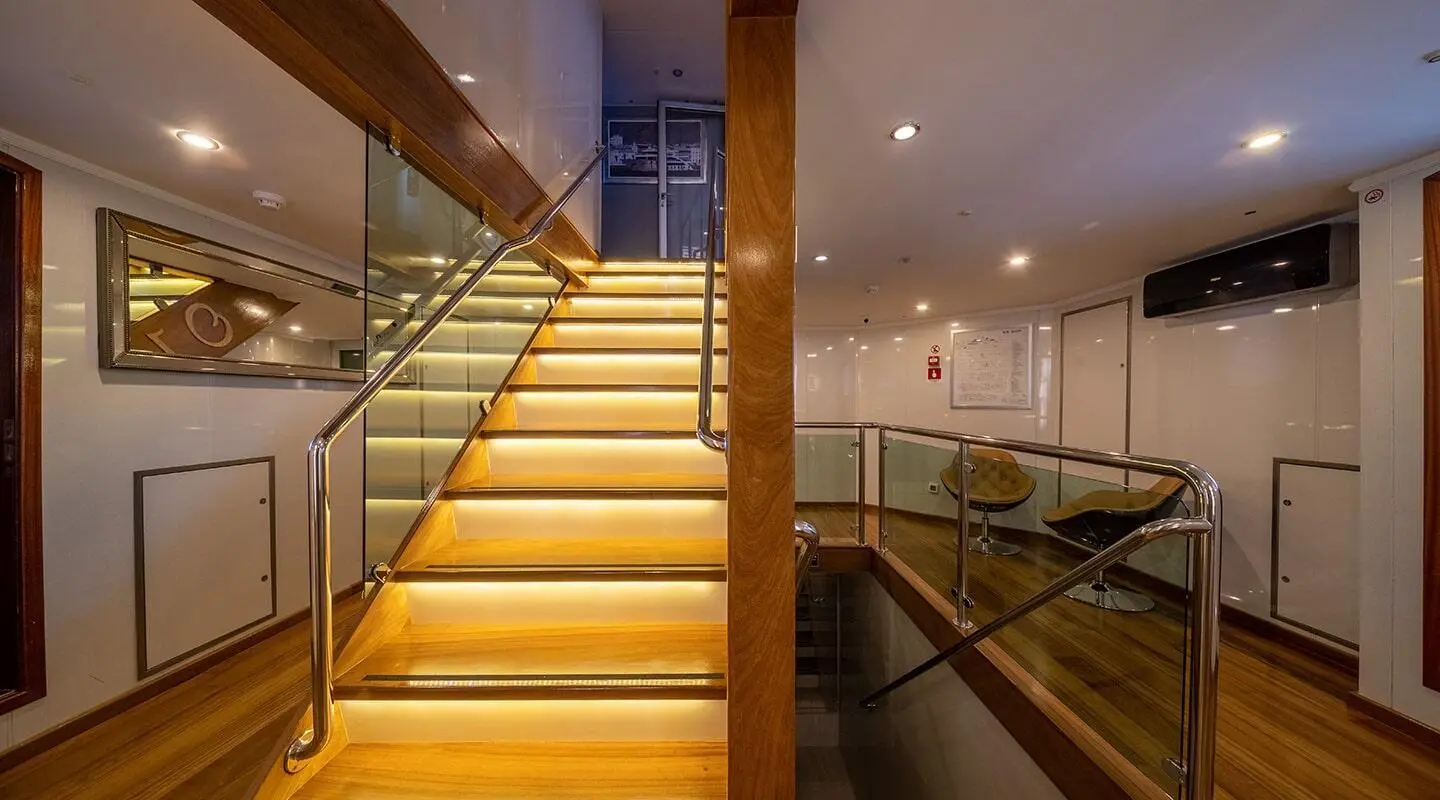 Olimp yacht interior staircase with wooden steps and glass railing