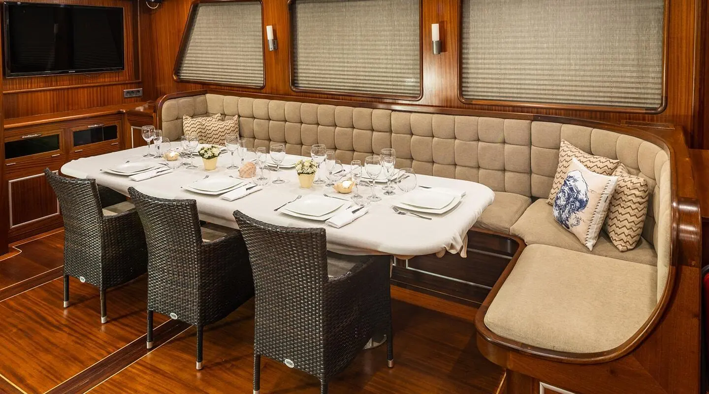 Luxurious yacht interior with wooden panels, dining table set for guests