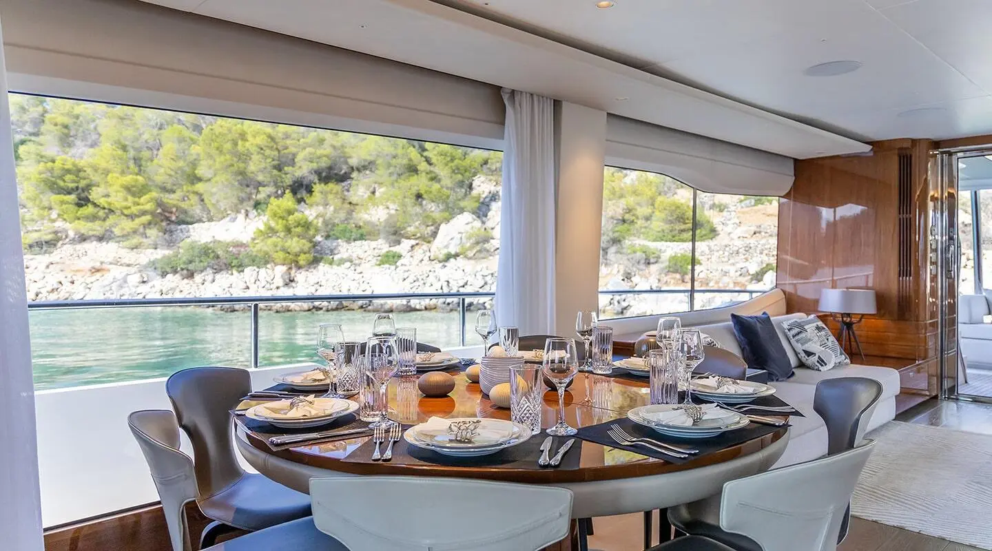 Yacht Vista saloon with table set for dining and large windows
