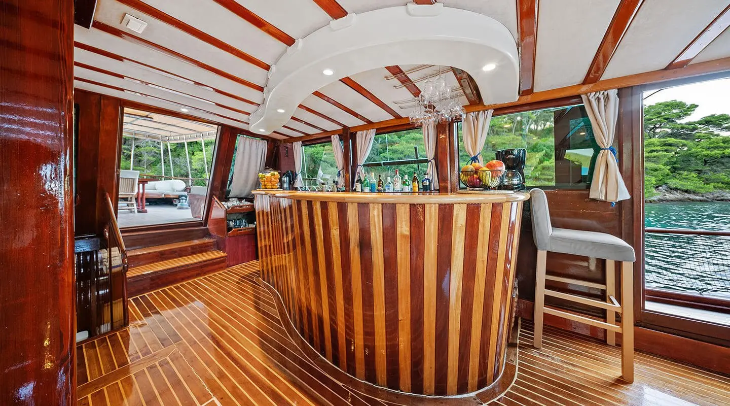 Elegant yacht cockpit area with polished wooden rails and seating under a white canopy