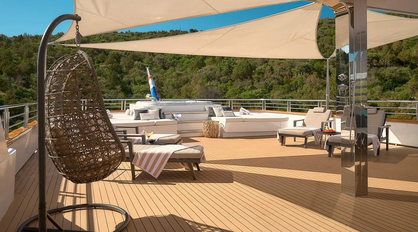 Cristal yacht deck with sun loungers, shaded seating, and a blue canopy