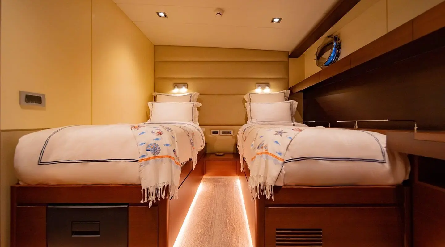 Double Eagle yacht interior with two single beds and warm wood panels