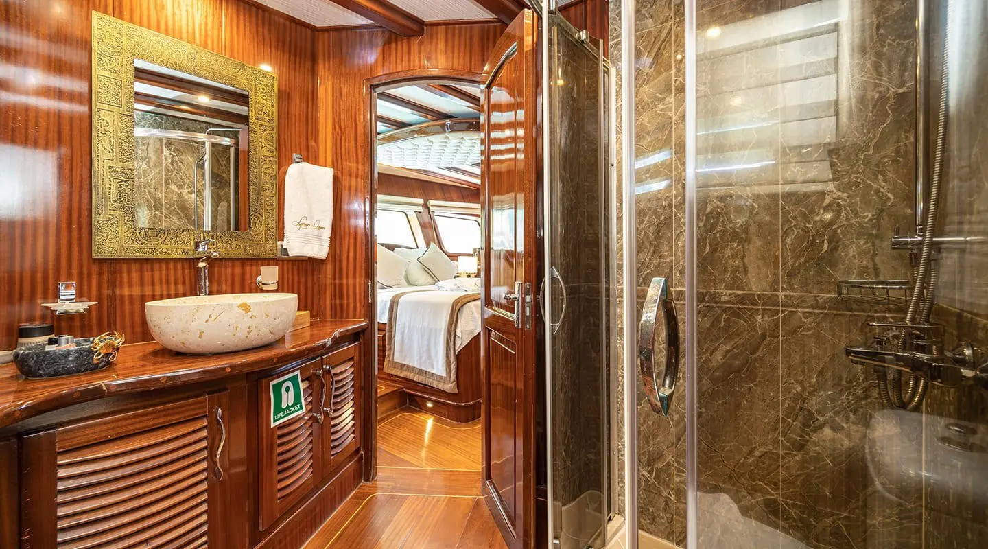 Interior of Lycian Queen master cabin with wooden accents and ensuite bathroom