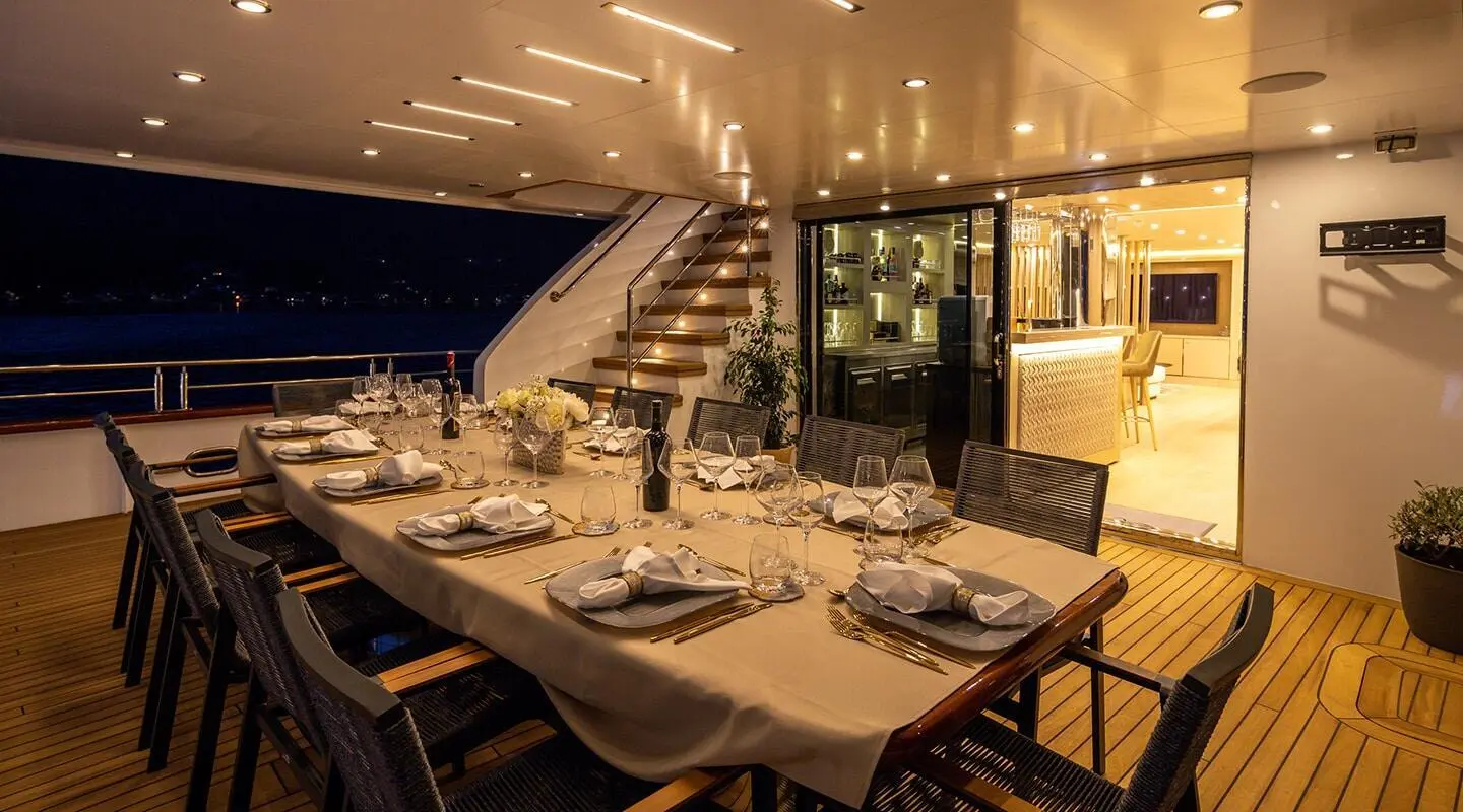 Love Story yacht at sunset with outdoor dining setup on deck