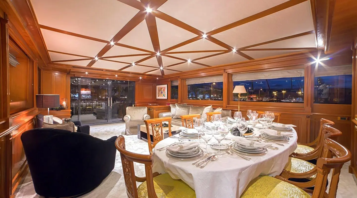 Luxurious wooden interior with a formal dining table set for a meal in a yacht