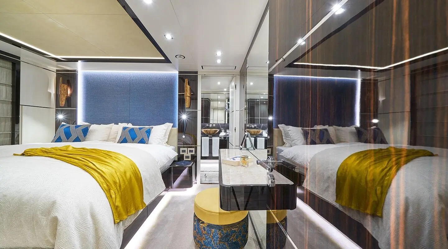 Interior view of a luxury yacht with a bed, seating, and bright decor