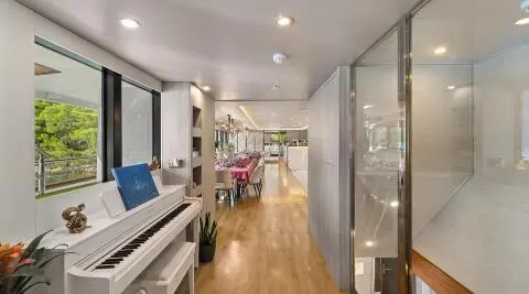 Luxurious yacht salon with a white piano and large windows overlooking greenery