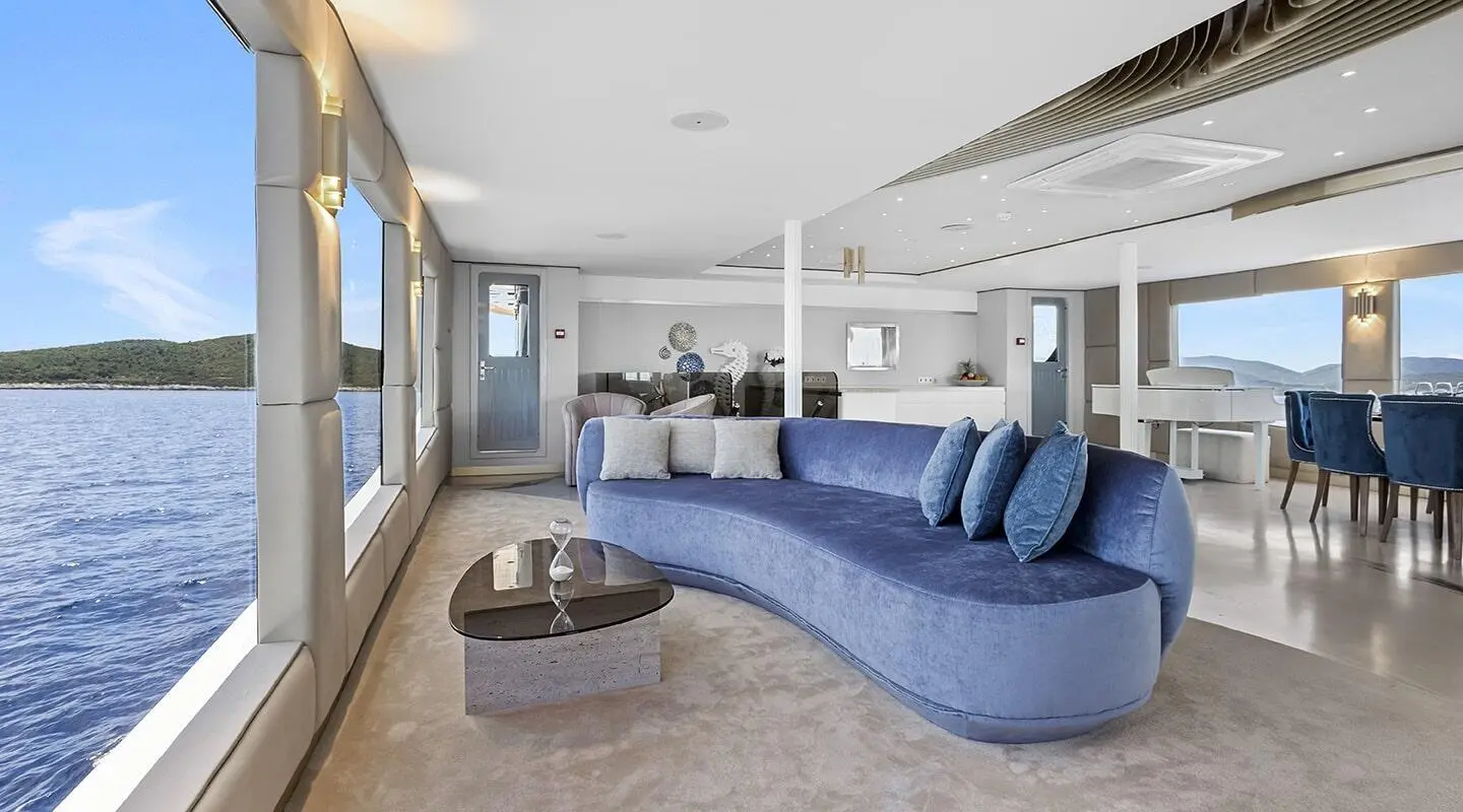 Interior of Bella yacht salon with blue curved sofa and lamp accents
