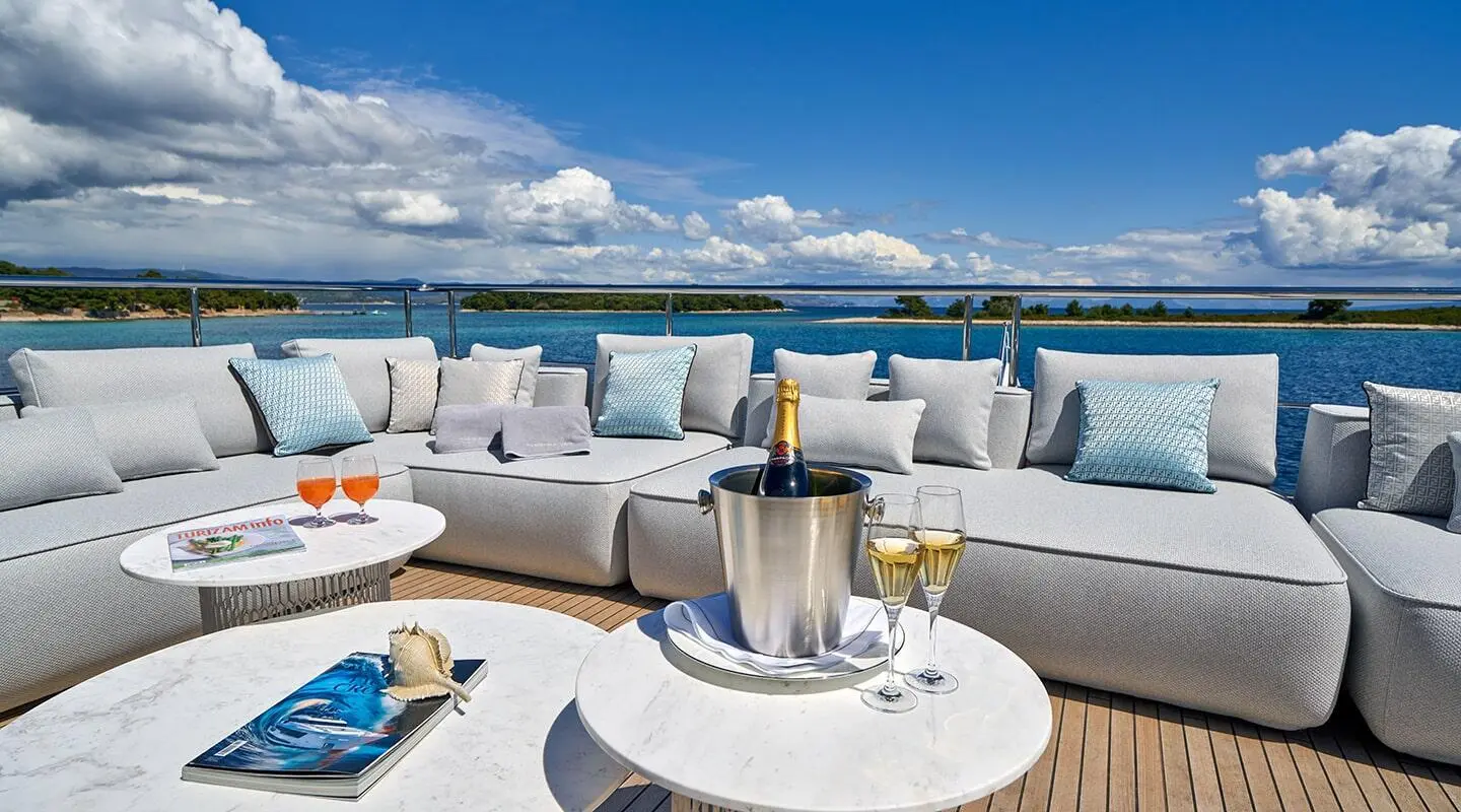 Yacht Aluminia Too exterior deck seating with blue sky and sea view
