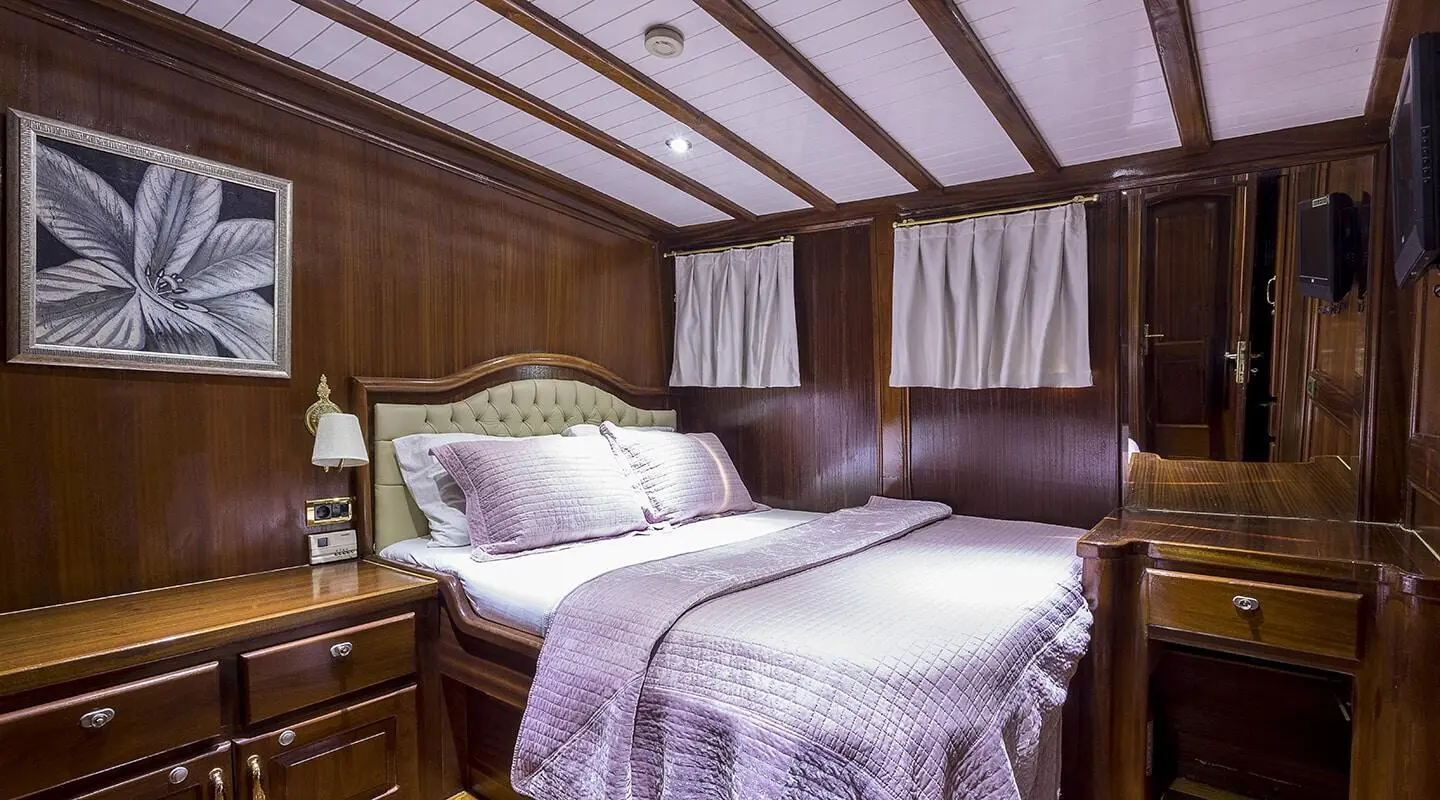 Interior of yacht Grace 1 with two large beds and wooden paneling