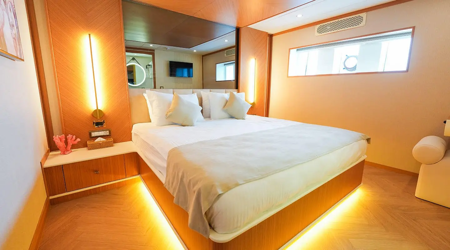 King of the Sea yacht interior with two-queen beds and warm lighting