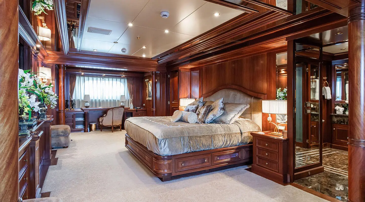 Luxurious yacht Apogee bedroom with wood-paneled walls and large bed