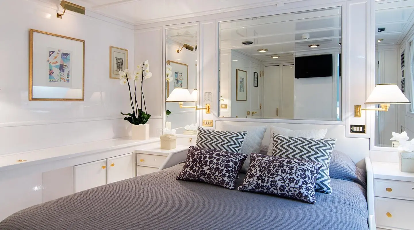 Interior of luxury yacht O'Natalina bedroom with bed and decorative pillows