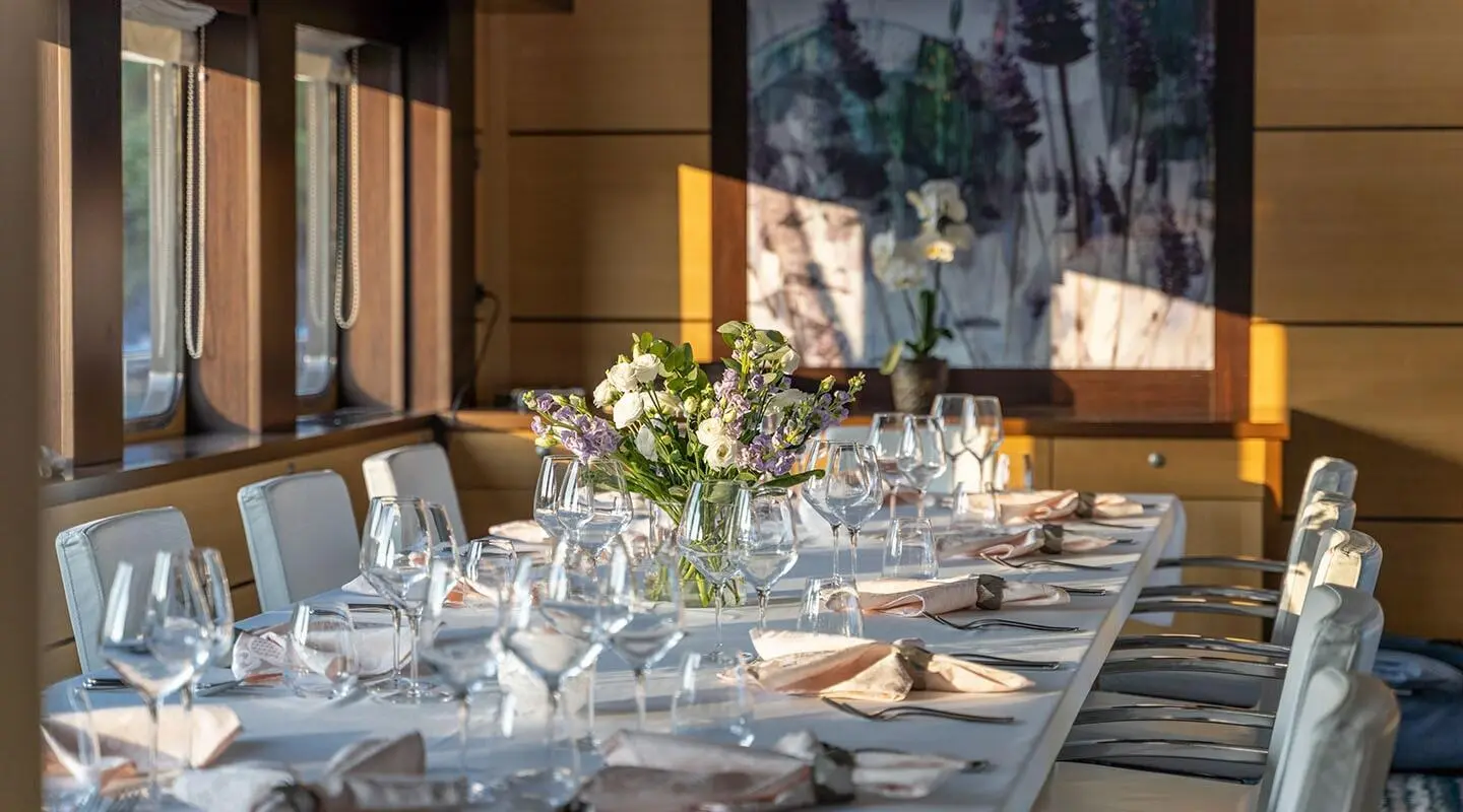Navilux yacht salon dining setup with table settings on deck
