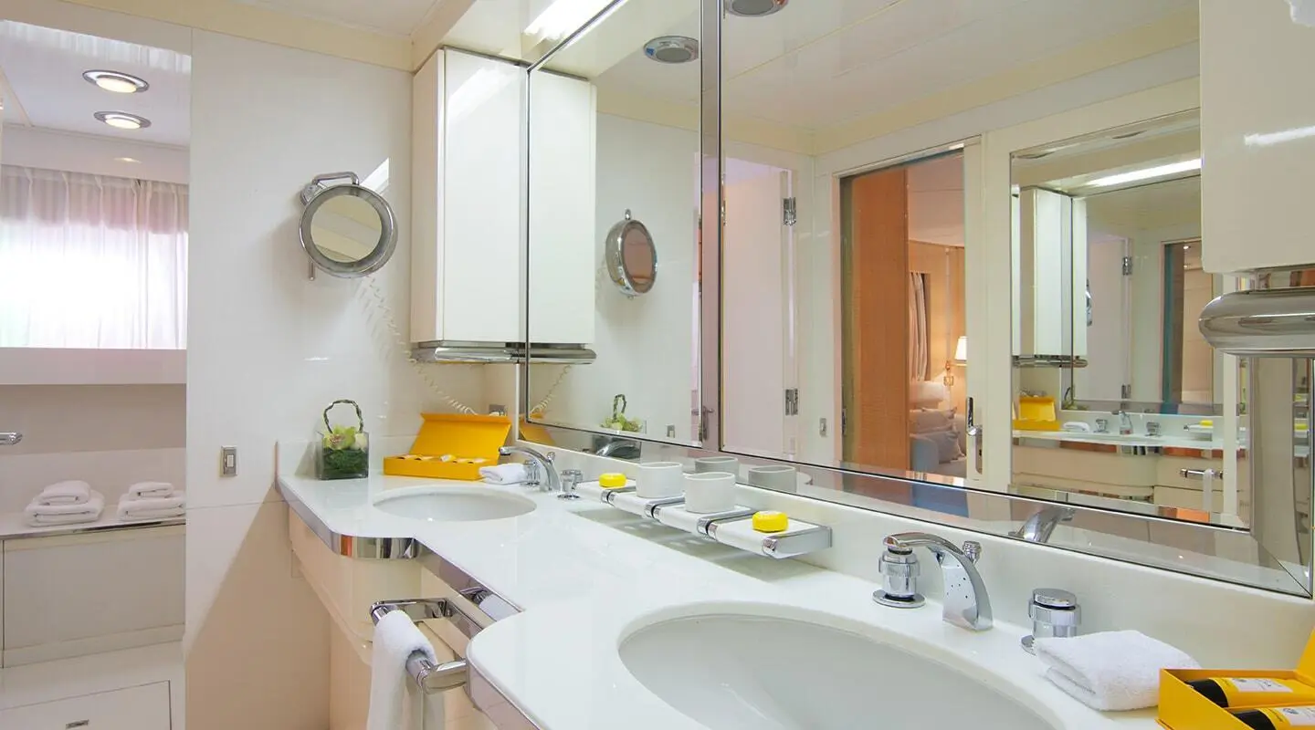 Bright bathroom with double sinks, mirrors, towels and vanity items