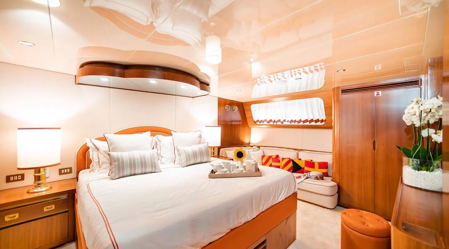 Cozy interior aboard Wind Of Fortune showing bed, seating, and warm lighting