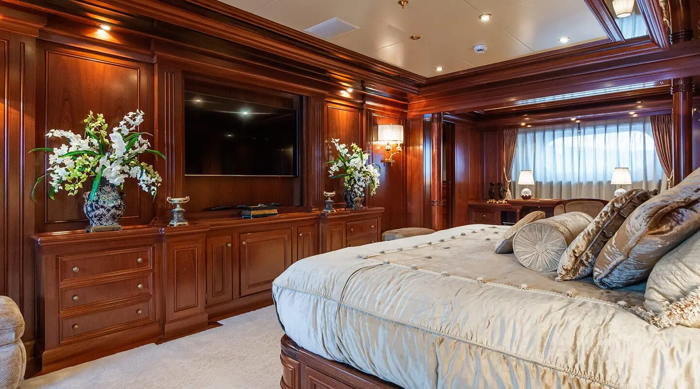 Apogee master cabin interior with wood paneling, two beds, and bedside lamps