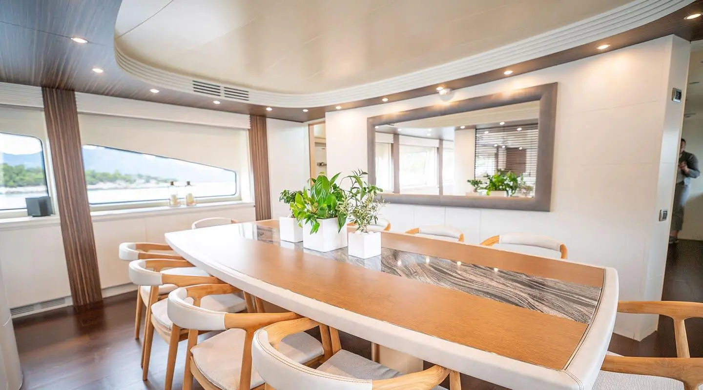Pareaki II yacht dining salon with wooden tables and large windows