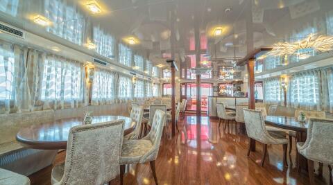Barbara luxury yacht interior dining area with round tables and plush upholstered chairs