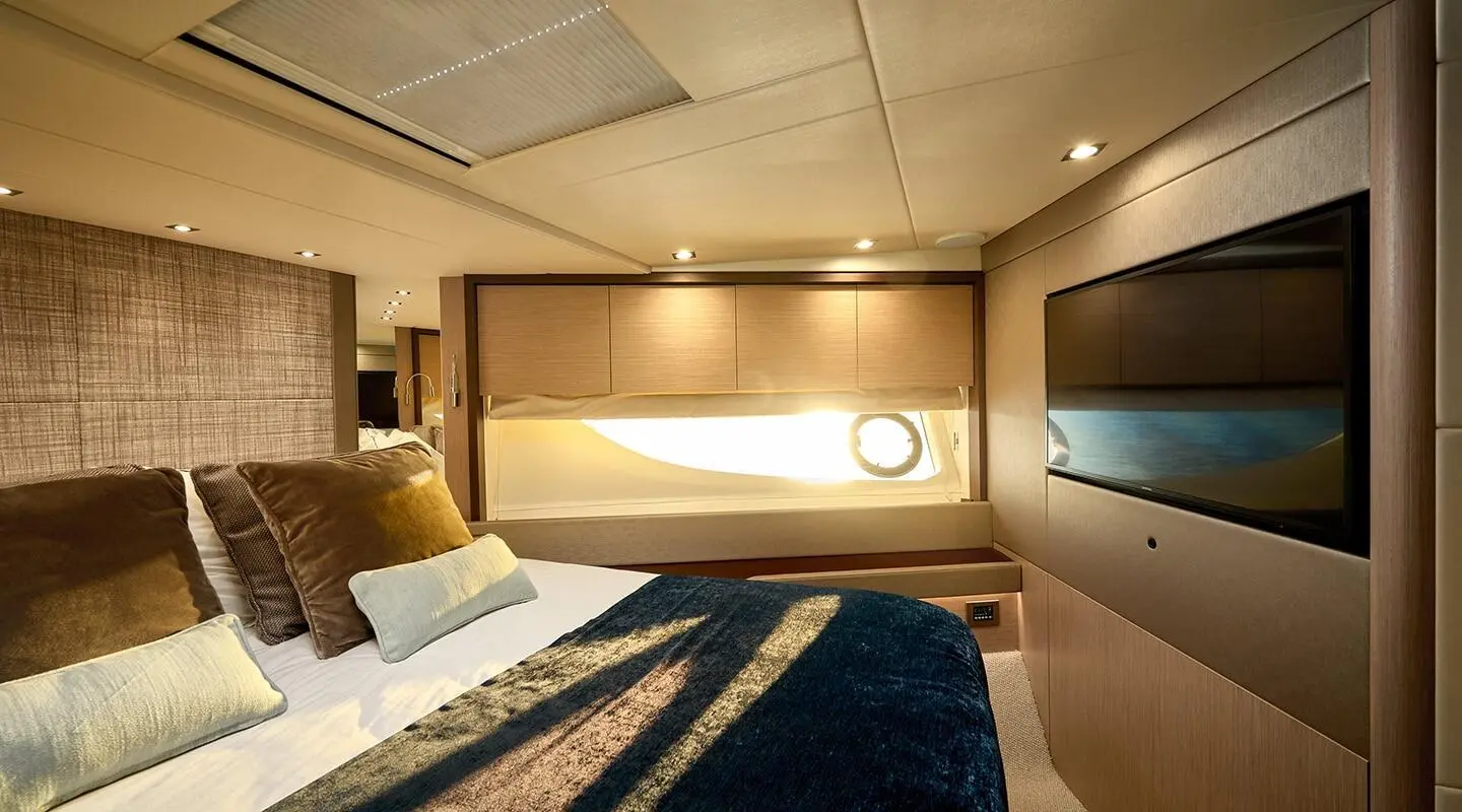 Bedroom aboard Hideaway yacht with bed, lamps, and warm ambient lighting