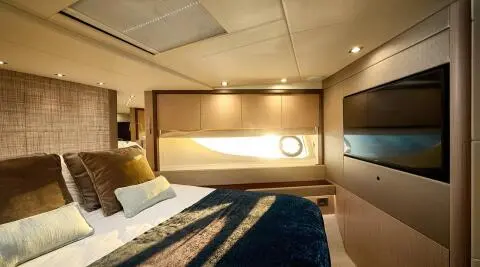 Bedroom aboard Hideaway yacht with bed, lamps, and warm ambient lighting