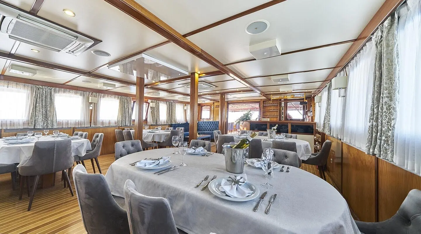 Interior of Amorena motor yacht dining area with white table settings