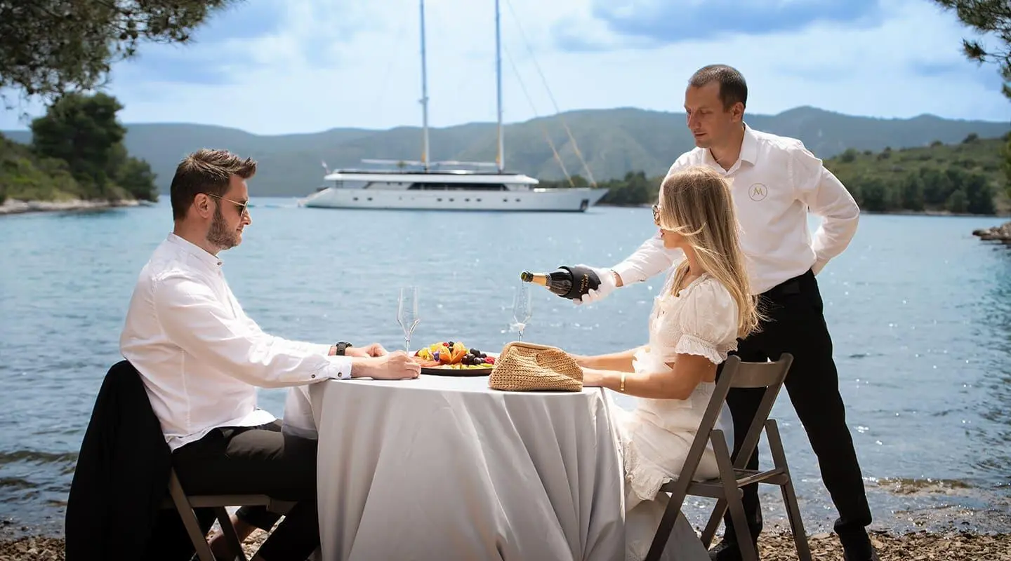 Yacht Anima Maris crew dining on deck with table set outdoors