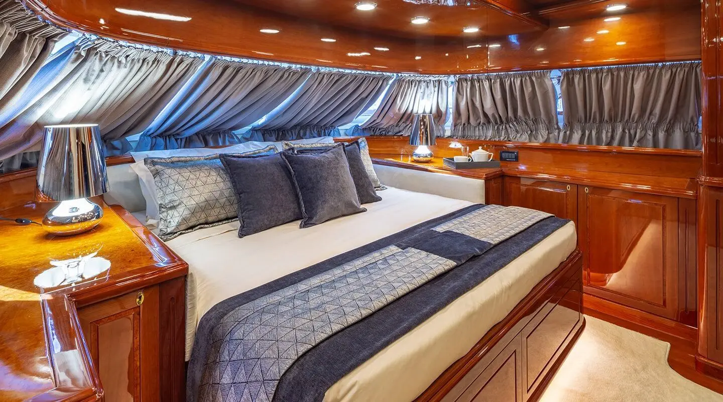 Luxurious yacht cabin interior with blue striped bed runner and pillows