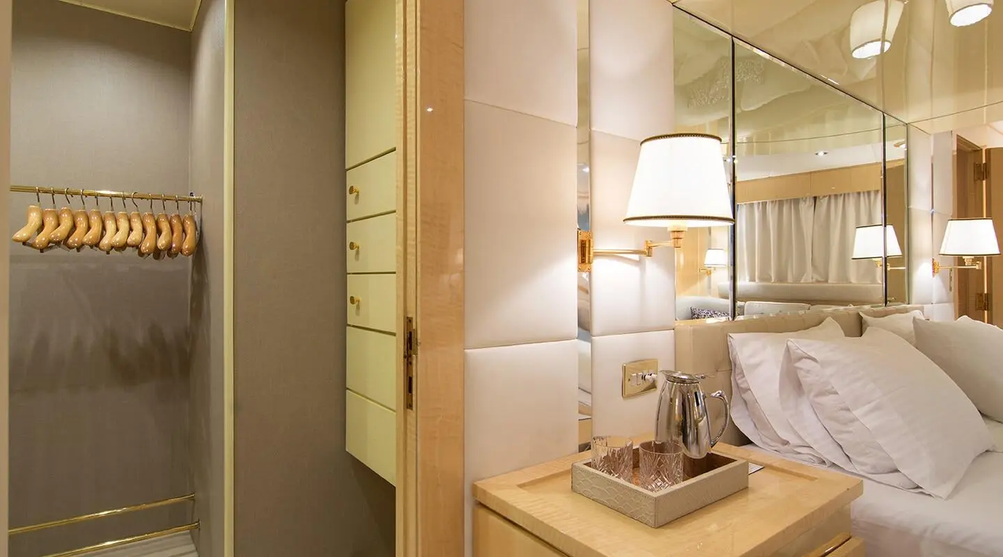 Luxurious yacht bedroom interior on O'Natalina with bed and bedside lamp