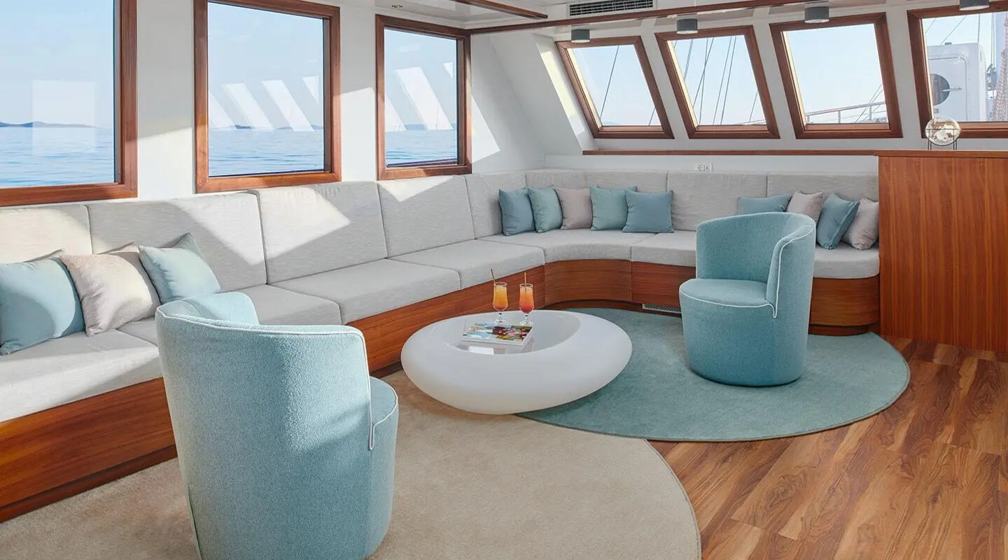 Corsario luxury gulet sailing interior with white cushions and blue seating at sunset