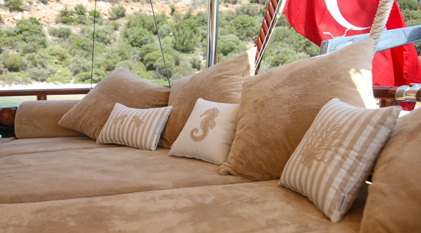 Gulet Ulucinar aft deck with beige cushions and decorative pillows