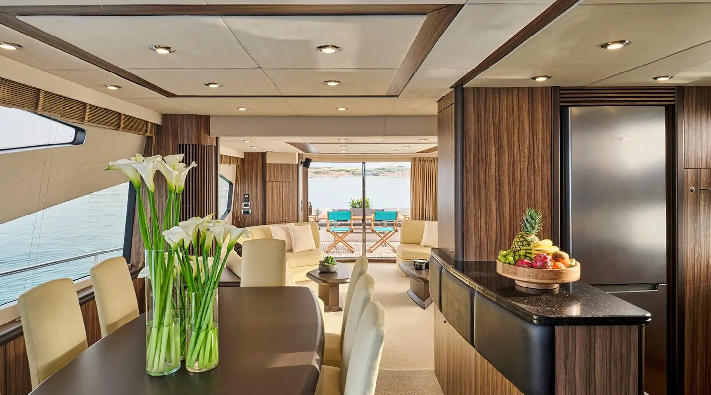 Interior view of M Five yacht saloon with seating, table, plants, and windows