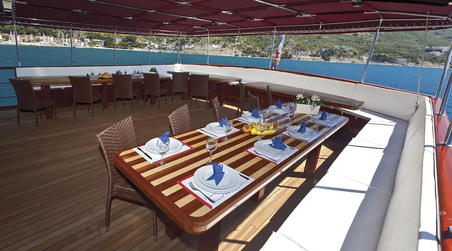 Amorena yacht dining aft deck set for elegant al fresco meal at sea
