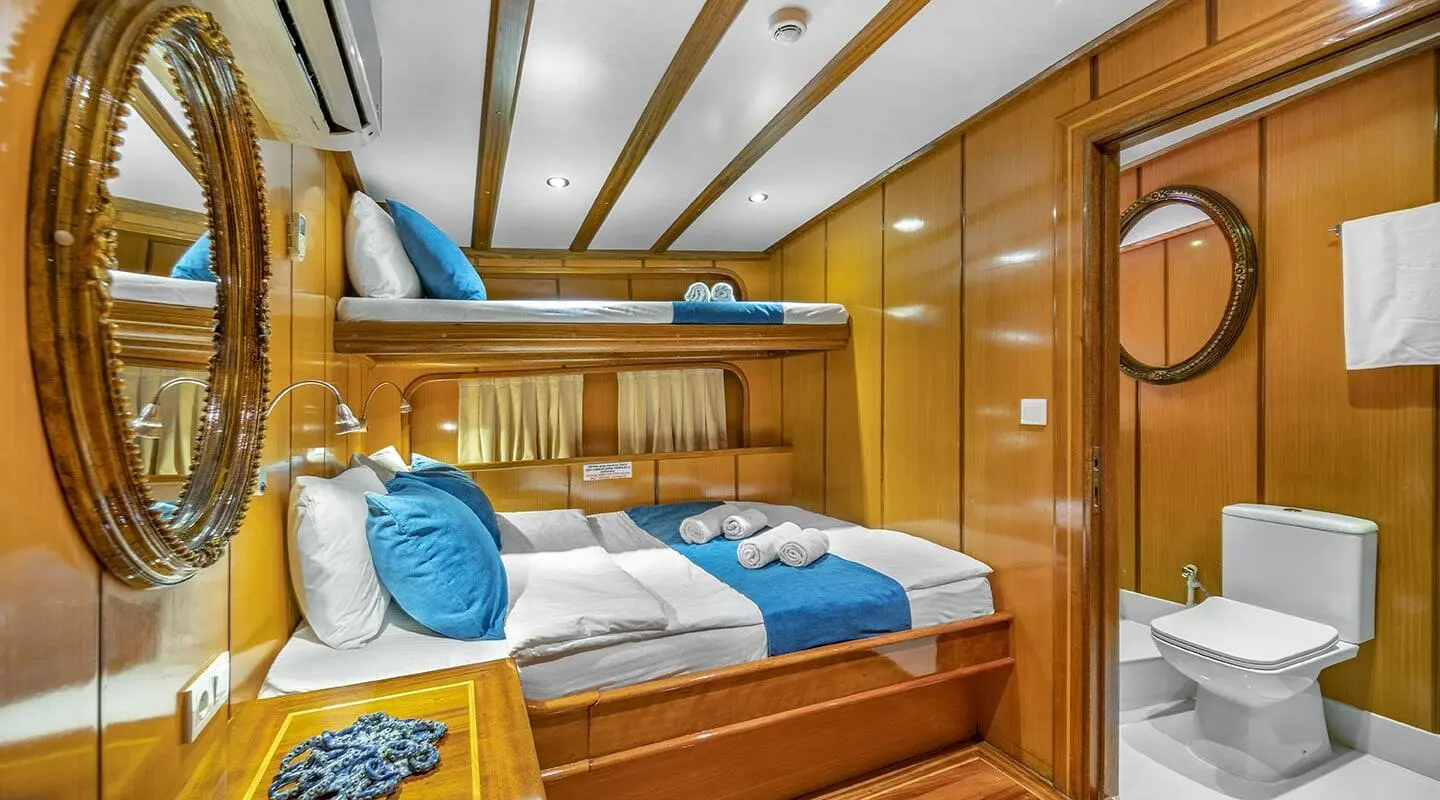 Yacht Tersane 8 interior cabin with wooden cabinetry and blue bedding