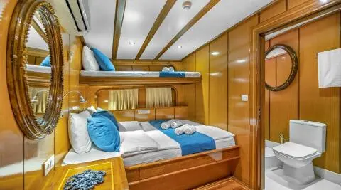 Yacht Tersane 8 interior cabin with wooden cabinetry and blue bedding