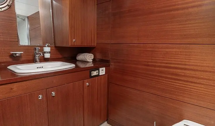 Compact cabin vanity area with wooden cabinets and white sink basin