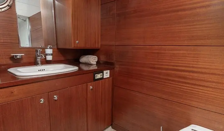 Compact cabin vanity area with wooden cabinets and white sink basin