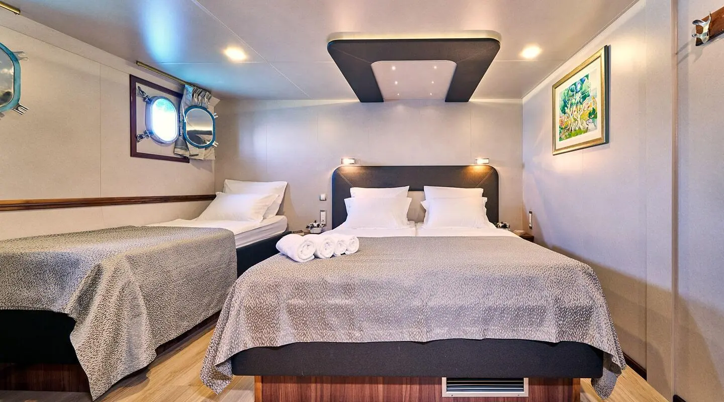 interior cabin aboard Casablanca yacht with two twin beds and soft lighting
