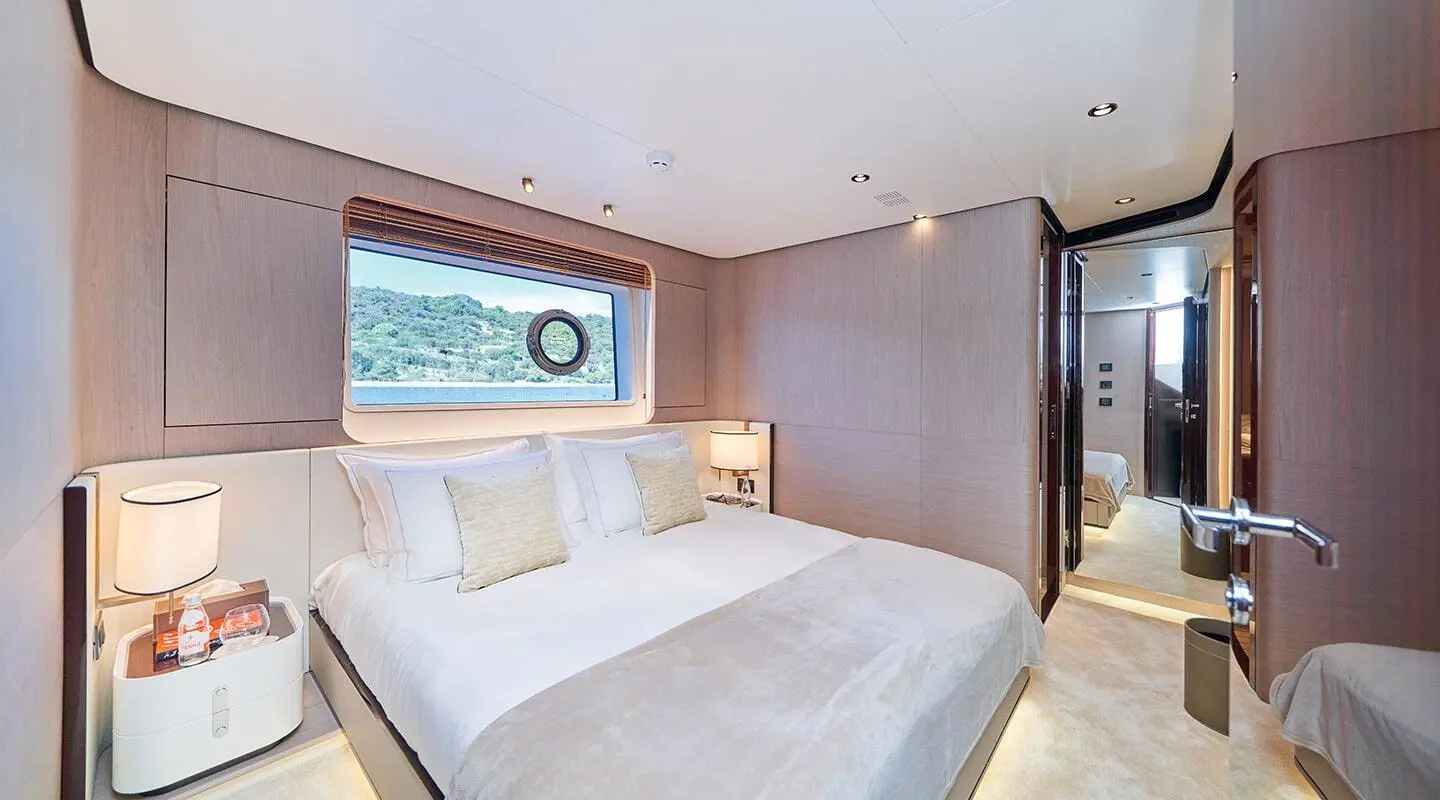 Aluminia Too yacht bedroom with large bed and beige paneling