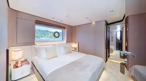Aluminia Too yacht bedroom with large bed and beige paneling