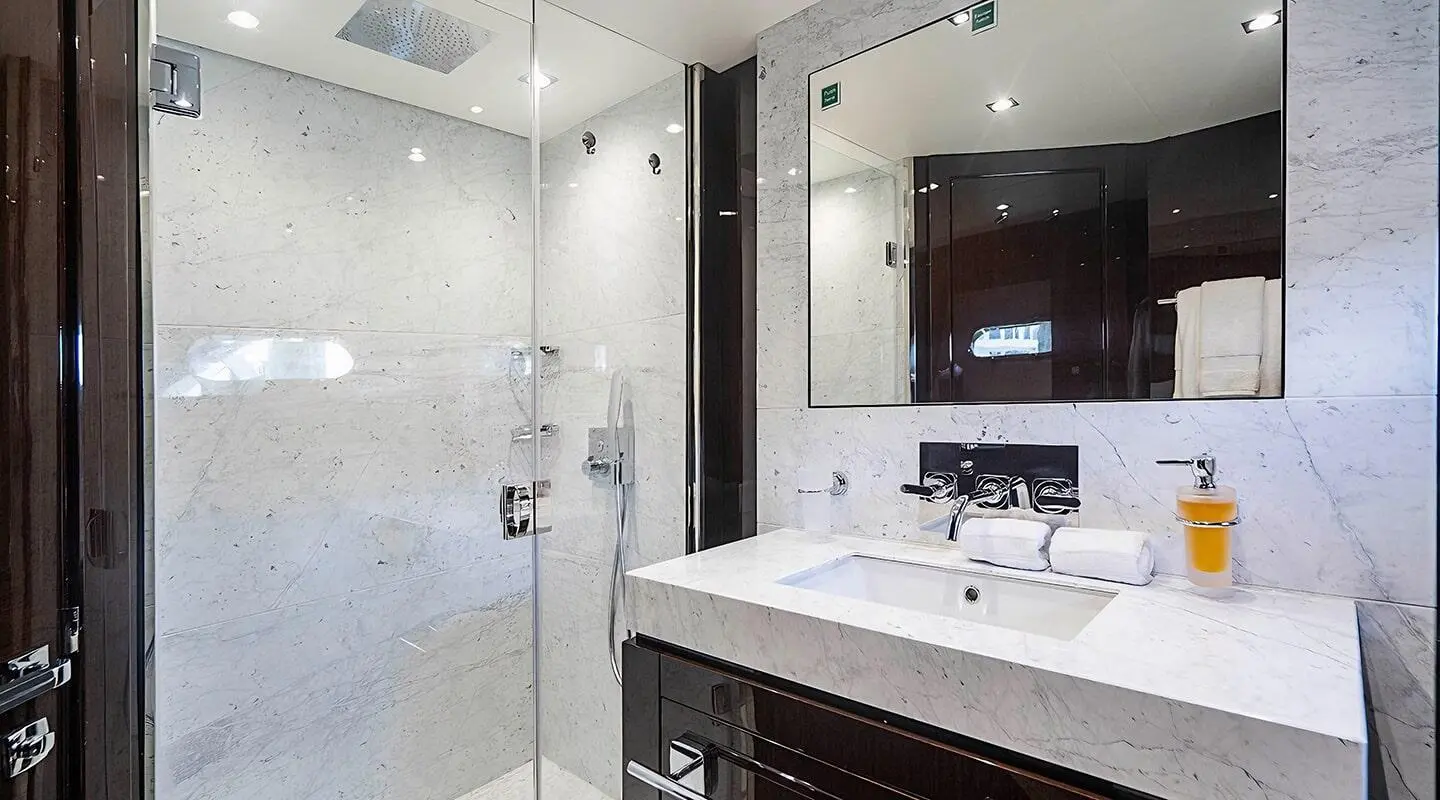 Quantum luxury yacht interior with marble bathroom sink and glass shower