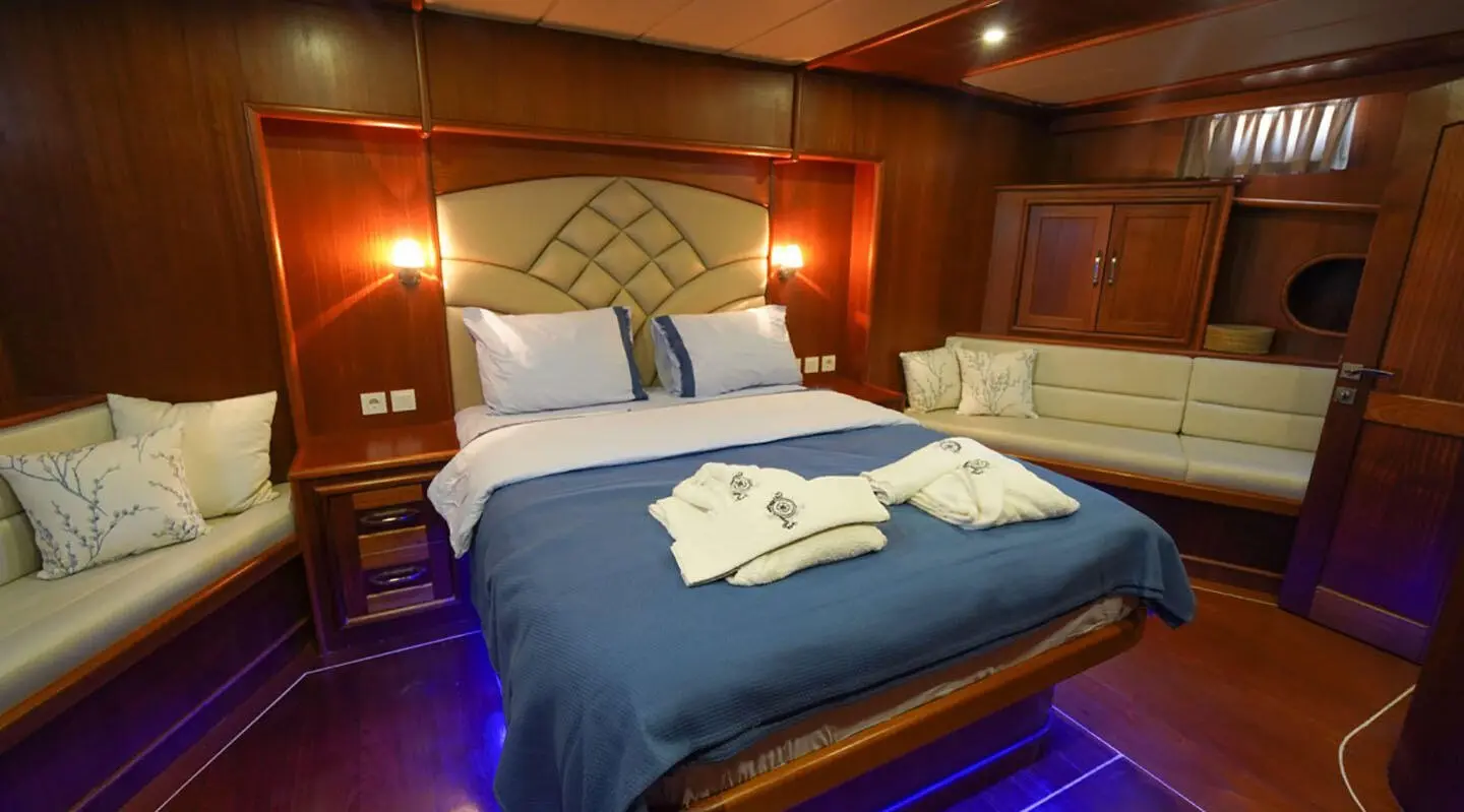 Luxurious bedroom aboard Prenses Esila with blue bedspread and neat towels
