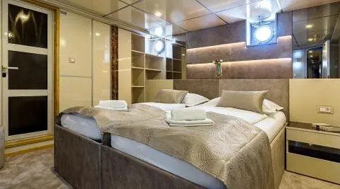 Luxurious yacht Melody stateroom with plush bedding and warm lighting
