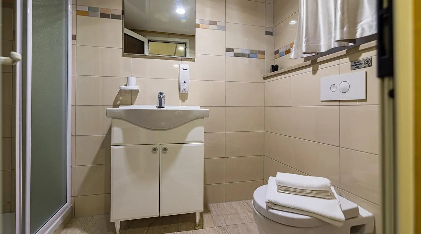 Yacht Melody bathroom interior with sink, mirror, tiled walls, and toilet
