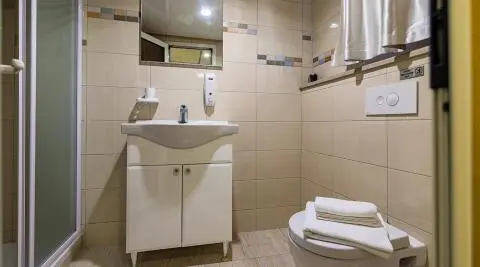 Yacht Melody bathroom interior with sink, mirror, tiled walls, and toilet